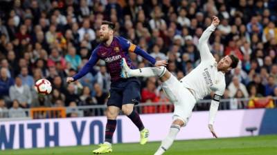 El defensa del Real Madrid Sergio Ramos (d) lucha con el argentino Leo Messi, del FC Barcelona, durante el partido de la 26ª jornada de Liga en Primera División, la pasada temporada. EFE/Juan Carlos Hidalgo/Archivo