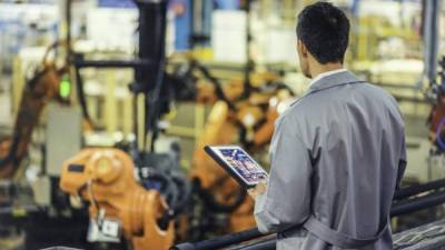 Un técnico revisa la operación automatizada de la fabricación de automóviles.