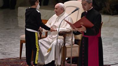 Un niño conversa con el Papa durante la audiencia general en el Vaticano.