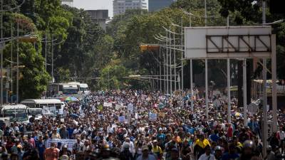 Cientos de manifestantes marcharon este lunes en Caracas al conmemorarse los 65 años de la caída de la dictadura militar del expresidente Marco Pérez Jiménez, para reclamar mejores salarios, mientras agentes de seguridad les bloquearon el paso hacia autopistas.