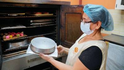 Mujer hondureña preparando una torta | Fotografía de archivo