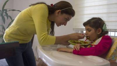 La madre de Grace, Mayela Benavides, dice que van por buen camino con el tratamiento a base de cannabis. AFP