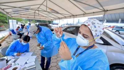 Una enfermera prepara una dosis de la vacuna de AstraZeneca en un punto de vacunación vehicular en la Unah.