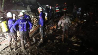 Equipos de rescate buscan supervivientes en una cancha arrasada por un alud en Quito.