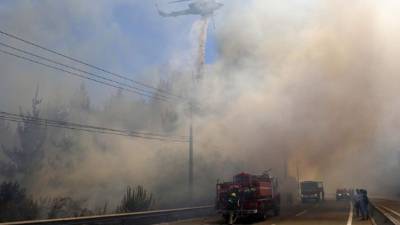Bomberos trabajando en el control de un incendio forestal en la ruta 66 acceso a Viña del Mar (Chile). EFE