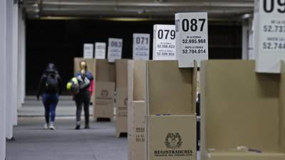 Dos mujeres caminan frente a puestos de votación, en el recinto de Corferias en Bogotá (Colombia).