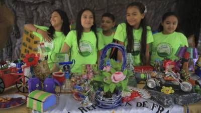 Estudiantes muestran hoy las manualidades que han realizado con materiales reciclables en Tegucigalpa. EFE