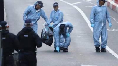 Tecnicos de escena del crimen recogen evidencias en el lugar de los ataques del sábado.