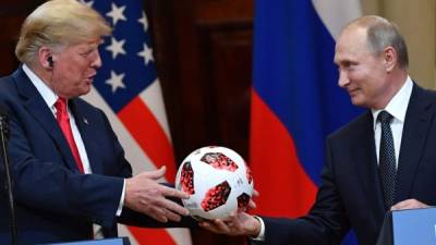 TOPSHOT - Russia's President Vladimir Putin (R) offers a ball of the 2018 football World Cup to US President Donald Trump during a joint press conference after a meeting at the Presidential Palace in Helsinki, on July 16, 2018.The US and Russian leaders opened an historic summit in Helsinki, with Donald Trump promising an 'extraordinary relationship' and Vladimir Putin saying it was high time to thrash out disputes around the world. / AFP PHOTO / Yuri KADOBNOV