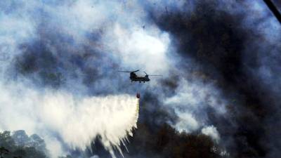 Helicopteros con bolsas de agua apagan incendio en bosque del Hatillo