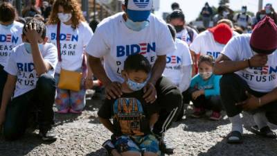 El inmigrante hondureño Fabricio García y su hijo Yadiel participaron en una protesta en Tijuana para pedir a Biden que los deje ingresar a EEUU./AFP.