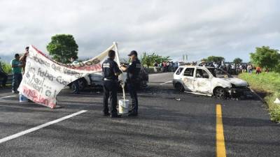 MEX6152. VILLAHERMOSA (MÉXICO), 01/07/2019.- Policías Federales recaban información en el lugar donde presuntos integrantes del crimen organizado bloquearon e incendiaron cinco vehículos, este lunes en Villahermosa (México). Presuntos integrantes del crimen organizado bloquearon e incendiaron varios vehículos en carreteras del suroriental estado mexicano de Tabasco y dejaron un mensaje de advertencia a la recién creada Guardia Nacional, que impulsó el presidente Andrés Manuel López Obrador. EFE/STR