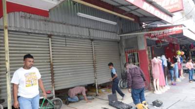 Soldadores y carpinteros trabajan en restaurar la tienda de ropa Nova Moda, en el centro de Choloma.