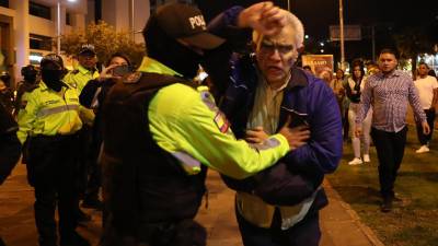 El jefe de Cancillería y Asuntos Políticos de la Embajada de México, Roberto Canseco, forcejea con policías para intentar evitar que trasladen al exvicepresidente Jorge Glas, condenado por corrupción.