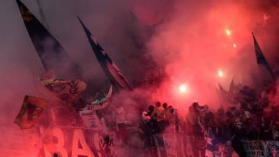 Los fanáticos de Marsella encienden bengalas antes del partido final de la UEFA Europa League entre el Olympique de Marseille y el Club Atlético de Madrid en el estadio Parc OL en Decines-Charpieu / AFP PHOTO / Jean-Philippe KSIAZEK