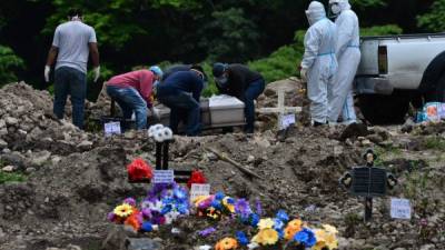 Los familiares entierran a una presunta víctima de COVID-19 en un anexo del cementerio Parque Memorial Jardín de los Ángeles, Tegucigalpa. AFP