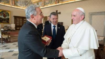 Álvaro Uribe saluda al papa Francisco; los observa Juan Manuel Santos, actual presidente colombiano.