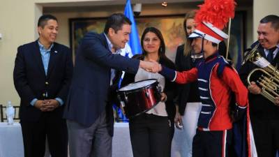 El presidente Juan Orlando Hernández entregando los instrumentos musicales.