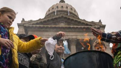 Un grupo de niños queman mascarillas quirúrgicas durante una manifestación contra las restricciones por la pandemia en Idaho./AFP.