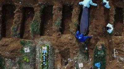 'Es uno atrás de otro. Esto no para', afirma uno de los sepultureros de Vila Formosa, el mayor cementerio de Sao Paulo y América Latina, vestido con un mono blanco y una máscara de tela cubierta con otra de acetato transparente para protegerse de la covid-19.