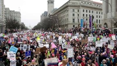 Los carteles que portan los manifestantes muestran la amplia gama de causas progresistas que defiende la marcha: 'Nosotros el pueblo somos más fuertes que el miedo'.