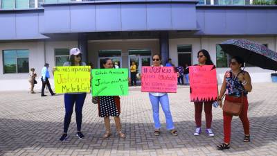 Mujeres con pancartas protestando afuera del Poder Judicial en San Pedro Sula.
