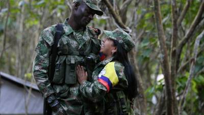 COLOMBIA. Última fiesta en armas. Una pareja de guerrilleros de las Farc celebró la Navidad en la selva, antes de entregar sus armas. Foto: EFE/CRIATIAN ESCOBAR MORA