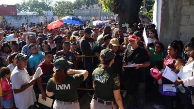 Personal del Instituto Nacional de Migración (INM) hablan con migrantes que esperan resolver su situación migratoria, el 31 de octubre de 2024, en la ciudad de Tapachula (México).