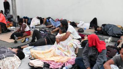 Migrantes descansan en las afueras de una iglesia Católica en Huixtla.