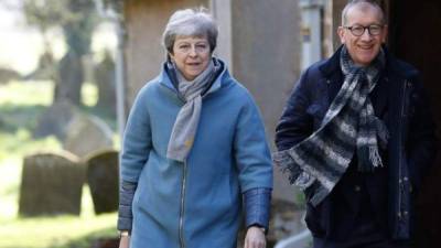 Theresa May captada ayer tras salir de una iglesia junto a su esposo Philip.Foto: AFP