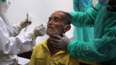 Personal médico practica una prueba de coronavirus a un paciente en Tegucigalpa. Más de la cuarta parte de las nuevas contrataciones se asignaron a la ciudad capital.