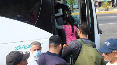 Migrantes de diferentes nacionalidades se suben a un autobús después de ser detenidos, imagen de archivo.
