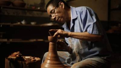 Fotografía del 10 de abril de 2018, que muestra al artesano Roberto Ramos mientras moldea en el torno de barro un pequeño cuenco, como parte de su trabajo en el taller Shicali, en San Salvador (El Salvador). EFE
