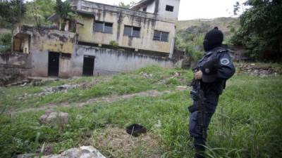 TEG01. COMAYAGUELA (HONDURAS), 20/11/13. Un policia patrulla este 20 de noviembre de 2013 una zona de la colonia Soto de Comayaguela donde pandillero an desalojado de sua casa personas y las an dejado en abandono.Frenar la ola de violencia criminal y el narcotráfico que golpean a Honduras son algunos de los retos que tendrá que afrontar el presidente que salga electo en los comicios del próximo domingo, indicaron hoy a Acan-Efe analistas.EFE/Gustavo Amador