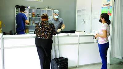 Dos pacientes esperan por medicinas en el triaje del Infop, donde están recibiendo de ocho a 10 consultas diarias.