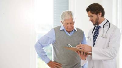 Cropped shot of a doctor talking to a senior patient in a clinic