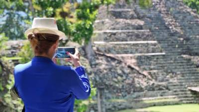 Una joven con mascarilla toma una foto de las ruinas mayas. Fotos: Mariela Tejada.