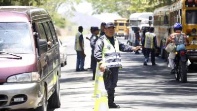 Un agente de la Policía de Tránsito pide a los conductores disminuir la velocidad en la carretera a Olancho.