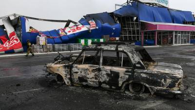 Un rescatista pasa junto a un coche averiado frente a un centro comercial destruido como resultado de un ataque con misiles, en Horlivka, Ucrania controlada por Rusia, el 25 de diciembre de 2023.
