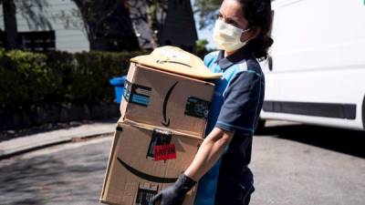 Una mujer de entrega de Amazon entrega paquetes en medio de la pandemia de coronavirus en Los Ángeles, California.