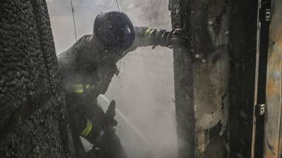 Bomberos ucranianos apagan el incendio de un edificio golpeado por un misil ruso en Kiev.