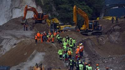 Cientos de personas participan en las labores de rescate en la aldea El Cambray II, sepultada por un deslave de tierra la semana pasada.