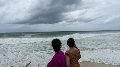 Turistas observan el mar en Bridgetown, Barbados, que se prepara para los efectos del huracán Beryl.