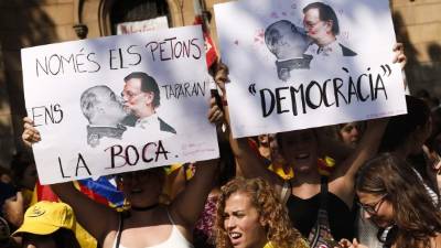 Estudiantes que se manifestaron ayer en Barcelona portaron pancartas donde se ve al jefe del gobierno español, Mariano Rajoy, besándose con el desaparecido dictador Francisco Franco.