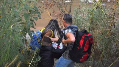 Una familia de migrantes centroamericanos cruzan este martes el Río Bravo. EFE