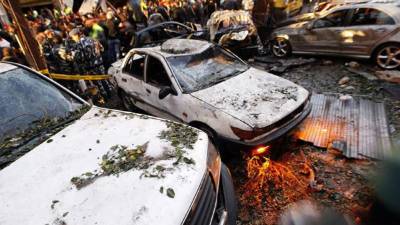 Miembros de las fuerzas de seguridad libanesas trabajan rodeados de curiosos en el lugar donde se ha registrado la explosión de un coche bomba en el barrio de Haret Hareik, en el sur de Beirut, el Líbano, hoy, jueves 2 de enero de 2014. Al menos cuatro personas murieron y más de nueve resultaron heridas en el atentado, informó la Agencia Nacional de Noticias. EFE/