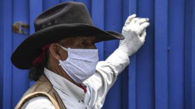 Un hombre se protege con una mascarilla del coronavirus en El Salvador. Foto: AFP