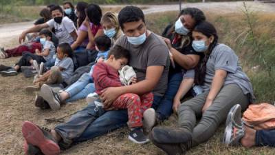 LA JOYA, TEXAS - APRIL 13: A Guatemalan family waits with fellow immigrants to board a U.S. Customs and Border Protection bus to a processing center after crossing the border from Mexico on April 13, 2021 in La Joya, Texas. A surge of immigrants, including record numbers of children, making the arduous journey from Central America to the United States has challenged U.S. immigration agencies along the southern border. John Moore/Getty Images/AFP== FOR NEWSPAPERS, INTERNET, TELCOS & TELEVISION USE ONLY ==