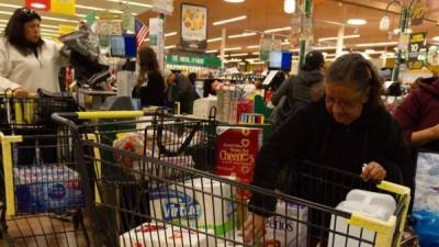 La mexicana María Marmolejo, de 62 años, empaca la mercancía comprada en un supermercado. EFE/Felipe Chacón/Archivo