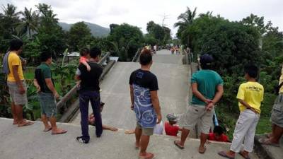 Varias personas observan los daños causados en un puente tras el terremoto de 6,7 grados de magnitud en la escala abierta de Righter que sacudió la ciudad de Surigao, en la provincia de Surigao del Norte, Filipinas. EFE